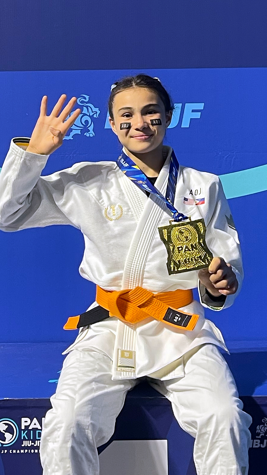 Bailey Heinsohn in her gi holding up four fingers after winning the 2026 IBJJF Pan Kids Championship.