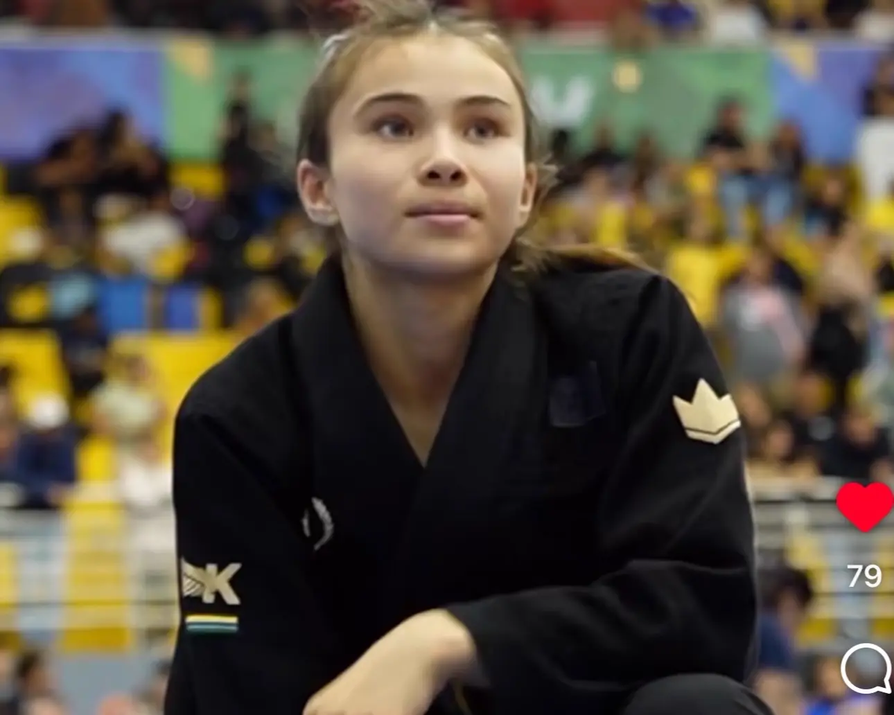 Bailey Heinsohn waiting mat-side in a black gi at a jiu-jitsu tournament.